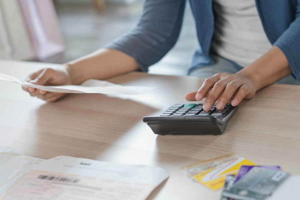 Woman using calculator with finance documents