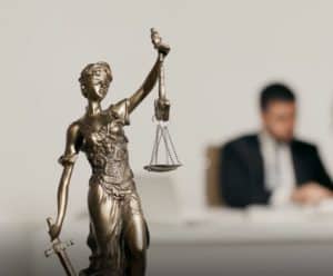 lady justice in the foreground with two people blurred in the background