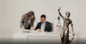 lady justice in the foreground with two people blurred in the background