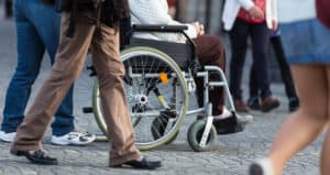 Pushing a wheelchair on the sidewalk