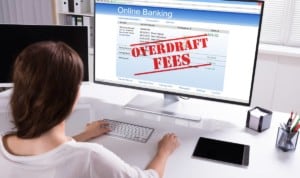 woman looking at screen with overdraft fees written