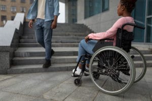 Young black disabled woman suffering from lack of wheelchair friendly facilities, cannot get home without ramp