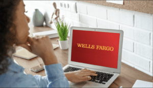Woman looking at laptop with Wells Fargo logo on screen