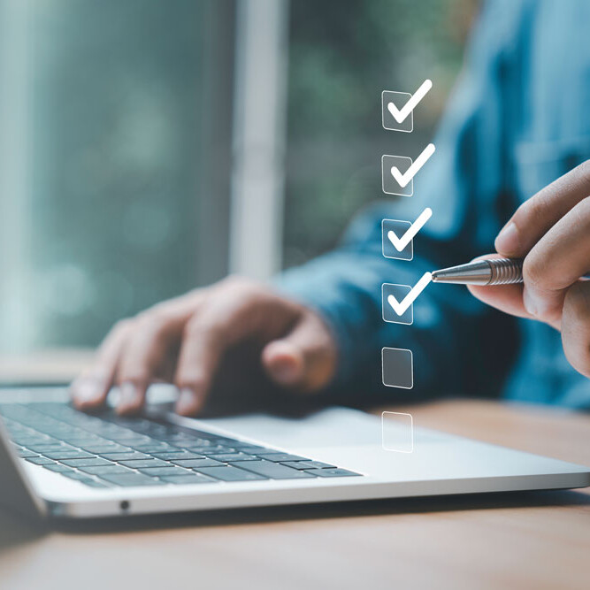 laptop with man drawing checkmarks